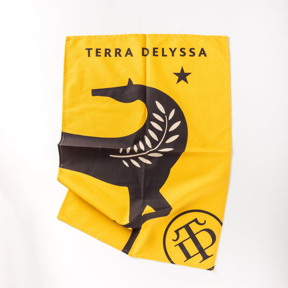 Terra Delyssa tea towel displayed flat on a white background, featuring the brand’s yellow and black horse logo on soft, absorbent cotton fabric.