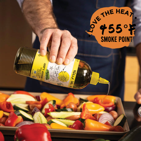 
                  
                    Hand pouring Bella Del Sol Organic High Oleic Sunflower Oil over a tray of colorful roasted vegetables with 455°F smoke point highlighted for high-heat cooking
                  
                