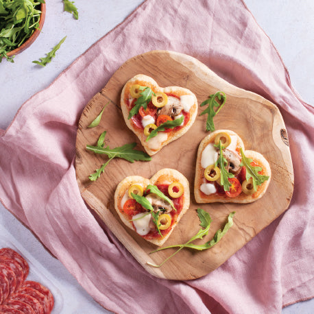 
                  
                    Mini heart-shaped pizzas topped with olives, cheese, arugula and tomato – romantic homemade snack idea – mini pizzas en forme de cœur avec fromage, olives, roquette et tomates
                  
                