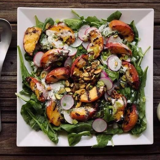 
                  
                    Salade de pêches grillées avec bébé roquette, pistaches et vinaigrette au yogourt citronné 
                  
                